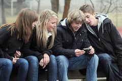Jugendliche sitzen auf einer Parkbank