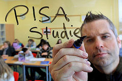 Lehrer schreibt die Wörter 'PISA Studie'