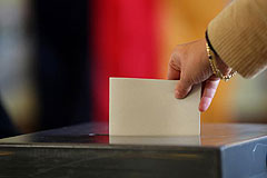 Whlerin wirft Stimmzettel in Urne
