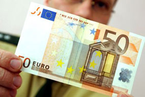 Ein Polizeibeamter hlt einen 50 Euro Geldschein in der Hand.