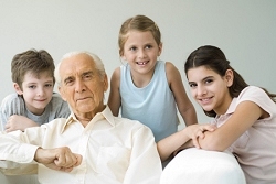 Foto: Familienprotrait, sitzend, Grovater und drei Enkel