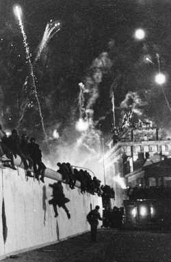 Foto: Menschen klettern ber die Berliner Mauer.