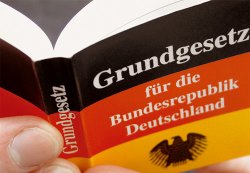 Symbolbild: Hand hlt das Grundgesetz fr die Bundesrepublik Deutschland