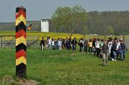 Schler passieren einen ehemaligen Grenzpfahl 