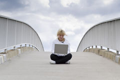 Frau mit Mobilcomputer auf Brücke