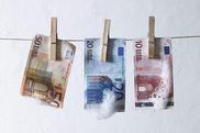 Geld hängt mit Wäscheklammern an einer Wäscheleine.