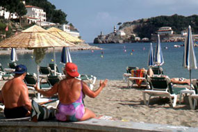 Mehrere Personen sitzen am Strand.