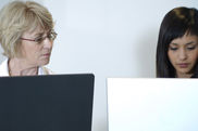 Zwei Frauen arbeiten an Laptops