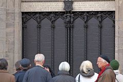 Touristen stehen vor Luthers Thesen in der Lutherstadt Wittenberg.