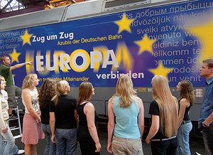 Jugendliche vor einer Lokomotive mit dem Schriftzug „Europa verbinden”.
