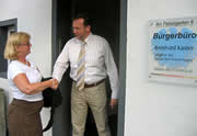 Der Abgeordnete Bernhard Kaster begrüßt eine Besucherin vor seinem Bürgerbüro.