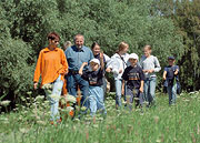 Bild: Eltern mit Kindern beim Spaziergang im Grünen.