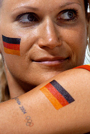 Bild: Gesicht einer jungen Frau mit auf die Wange gemalter deutscher Fahne 