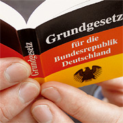 Bild: Aufgeschlagenes Grundgesetz mit schwarz-rot-goldenem Cover