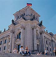 Bild: Paar sitzt vor Eckturm des Reichstagsgebäudes