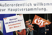 Bild: Demonstranten mit Plakat: Manager 100 Millionen Plus! Arbeitnehmer 20% Minus?