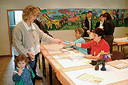 Bild: Mutter mit Kind bekommt Stimmzettel