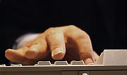 Bild: Hand auf Computertastatur.