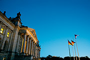 Das Reichstagsgebäude in der Abenddämmerung. Im Präsidialbüro brennt noch Licht.