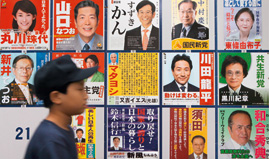 Junge vor japanischen Wahlplakaten