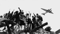 Kinder winken während der Luftbrücke einem Rosinenbomber zu