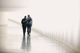 Hauptdarsteller João Baroso und Filmemacher Jan Zabeil gehen Arm in Arm einen Gang im Bundestag entlang