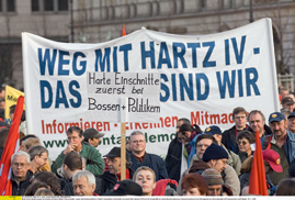 Demonstranten mit Plakaten demonstrieren gegen die Hartz-IV-Gesetze
