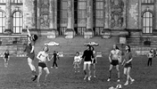 Junge Männer spielen vor dem Reichstagsgebäude Fußball