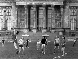 Junge Männer spielen vor dem Reichstagsgebäude Fußball