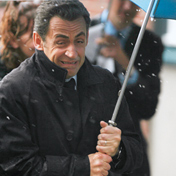 Nicolas Sarkozy mit einem Regenschirm