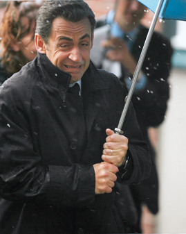 Nicolas Sarkozy mit einem Regenschirm
