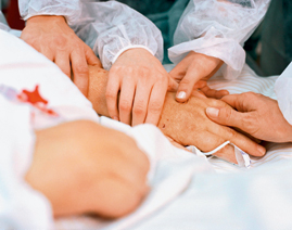 Angehörige halten die Hand eines Patienten