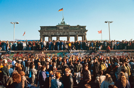 Menschen klettern auf die Mauer vor dem Brandenburger Tor am 10. November 1989