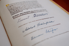 Beurkundungsseite des Grundgesetzes von 1949 mit den Unterschriften von Konrad Adenauer (CDU), Adolph Schönfelder (SPD) und Hermann Schäfer (FDP)