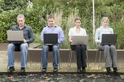 Vier Personen arbeiten an Laptops