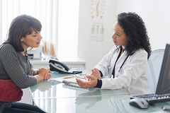 Patientin und Ärztin führen ein Gespräch am Tisch