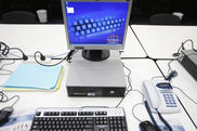 Arbeitsplatz mit Desktoprechner, Bildschirm, Tastatur, Maus, Kophörern, Telefon