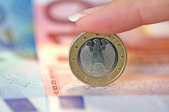Euroscheine und Eineuromünze mit Bundesadler