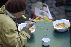 Alte Frau isst eine Suppe beim Franziskanerkloster.