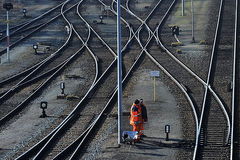 Bahnarbeiter stehen auf den Gleisen.