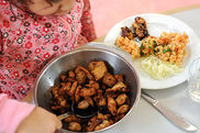 Ein Kita-Kind füllt sich essen auf.
