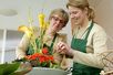 Floristinnen in ihrem Blumengeschäft bei der Anfertigung eines Blumengestecks