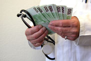 Ein Arzt hält viele Geldscheine