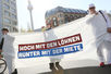 Drei Demonstranten fordern höhere Löhne und geringere Mieten