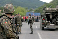 Ein deutscher Soldat (im Vordergrund) und gepanzerter Transportwagen