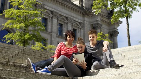 Jugendliche mit einem Tablet vor dem Reichstagsgebäude