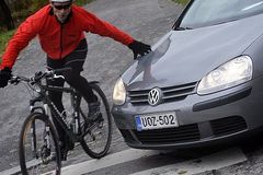 Fahrradfahrer vor Motorhaube eines Autos