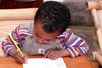 Kinde schreibt auf einem Tisch