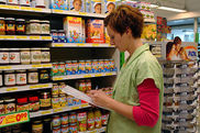 Angestellte kontrolliert Warenregale im Supermarkt 