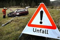 Unfall mit Unfallwagen auf Wiese und Warnschild 'Unfall'